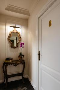 a hallway with a door and a table with a mirror at Ateneea Luxury Rooms in Cluj-Napoca