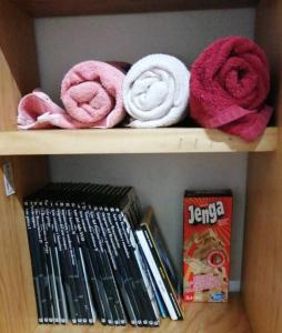 een boekenplank met roze handdoeken en een doos bij casa céntrica colonial in Morelia