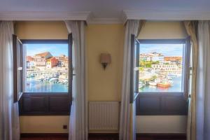 two windows in a room with a view of a harbor at Las Rocas in Llanes