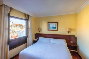 Un dormitorio con una cama grande y una ventana en Las Rocas en Llanes