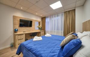 a bedroom with a blue bed with a desk and a television at Sleep1c in Hamburg