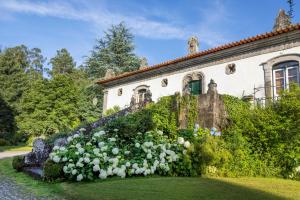 a house with a flower garden in front of it at Casa de Juste in Lousada