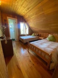 プエルト・バラスにあるLa Cantaría Hostal & Restobarの木造キャビン内のベッドルーム1室(ベッド2台付)