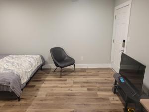 a bedroom with a chair next to a bed at The Place To Stay in Alvin