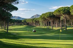a view of a golf course with mountains in the background at Empordà Golf Resort in Torroella de Montgrí