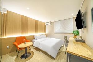 a hotel room with a white bed and a desk at No 25 Hotel Dongam Branch in Incheon