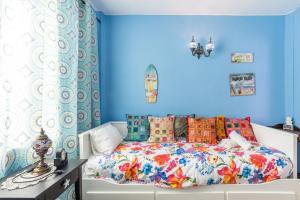 um quarto com paredes azuis e uma cama com almofadas coloridas em Javea Family Oasis: Steps from the Beach em Platja de l'Arenal