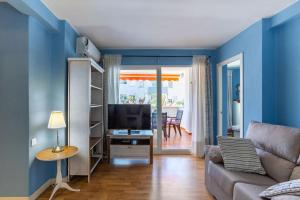 uma sala de estar com um sofá e uma televisão em Javea Family Oasis: Steps from the Beach em Platja de l'Arenal