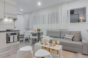 a living room with a gray couch and a kitchen at Super Centro y Playa by TheBlueWaveApartments com in A Coruña