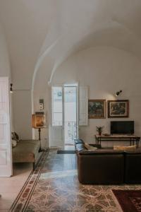 ein Wohnzimmer mit einem Sofa und einem Tisch in der Unterkunft Casa Del Tempio Antico, Salento in Arnesano