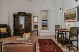 ein Wohnzimmer mit einem Sofa und einem Tisch in der Unterkunft Casa Del Tempio Antico, Salento in Arnesano