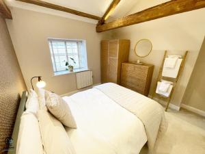 Un dormitorio con una gran cama blanca y una ventana en Character filled Courtyard Escape en Harrogate