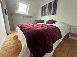 ein Schlafzimmer mit einem Bett mit einer roten Decke darauf in der Unterkunft Maison de pêcheur Etel in Étel