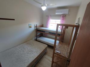 a room with two bunk beds and a window at Casa de Praia do Adriano in Itapoa