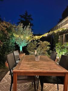 a wooden table with chairs and lights on a patio at Ruhige Wohnung mit Terrasse in Telgte +9 photos