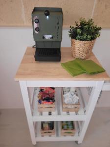 una macchina da cucire seduta su un tavolo con una pianta di Casa Lori,73 a Grottaglie