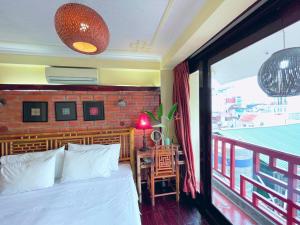 um quarto com uma cama e uma varanda com vista em May - Maison De Charme LP em Hanói