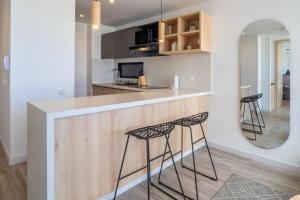 a kitchen with two bar stools and a mirror at Classy 1BR in Chapinero in Bogotá