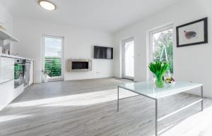 a white living room with a table and some windows at Haus Wolkentraum - Fewo Traum mit Terrasse und Bio-Kamin in Zinnowitz