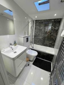 a bathroom with a sink and a toilet at Stunning 3BR Maisonette in Brixton in London