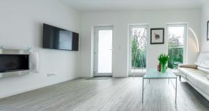a white living room with a couch and a tv at Haus Wolkentraum - Fewo Traum mit Terrasse und Bio-Kamin in Zinnowitz