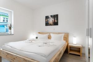 a bedroom with two beds with white sheets and a window at Haus Wolkentraum - Fewo Traum mit Terrasse und Bio-Kamin in Zinnowitz +12 photos