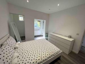 a bedroom with a bed and a dresser and a window at Stunning 3BR Maisonette in Brixton in London