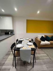a dining room with a table with chairs and a couch at Stunning 3BR Maisonette in Brixton in London +12 photos