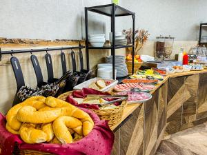 ein Buffet mit Brot und Speisen in der Unterkunft Park Hotel Sóstó in Nyíregyháza