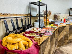 una línea de buffet con pan y platos de comida en Park Hotel Sóstó, en Nyíregyháza