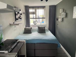 a small bedroom with a bed and a window at Landelijk Hijken in Hijken