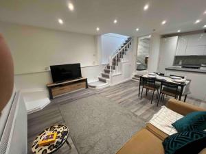 a living room with a couch and a table and a kitchen at Stunning 3BR Maisonette in Brixton in London