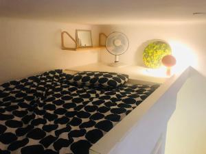 a bedroom with a black and white bed and a fan at Charming apartment in Töölö with Nordic design in Helsinki