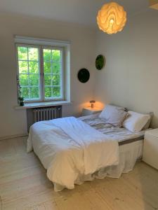a white bedroom with a large bed and a window at Charming apartment in Töölö with Nordic design in Helsinki