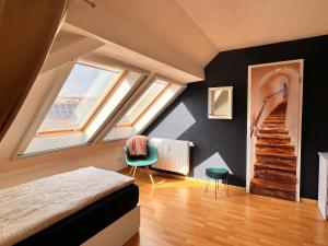 1 dormitorio con paredes negras y 1 cama con silla verde en Ferienwohnung Aurora - WLAN, 2 Schlafzimmer, TV, Küche, Bad, Waschmaschine, en Malterdingen