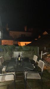 tavolo e sedie con una bottiglia di vino sopra di Nada's room with terrace a Kotor (Cattaro)