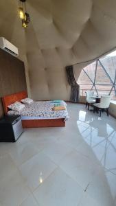 a bedroom with a bed and a table and chairs at rum guest house in Wadi Rum