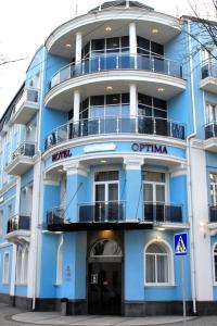 un edificio azul con un cartel delante en Optima Collection Khmelnytskyi, en Khmelʼnytsʼkyy