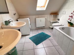 a bathroom with a sink and a tub and a toilet at Ferienwohnung Aurora - WLAN, 2 Schlafzimmer, TV, Küche, Bad, Waschmaschine in Malterdingen