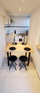 a kitchen with a wooden table and two stools at Superbe cocon en bord du lac in Publier