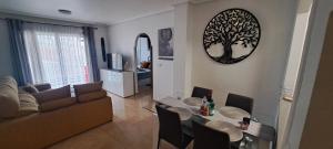 a living room with a couch and a table with chairs at Apartament Julia de LUX in Torrevieja