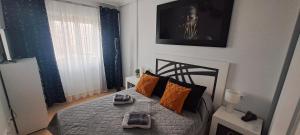 a small bedroom with a bed with orange pillows at Apartament Julia de LUX in Torrevieja +41 photos
