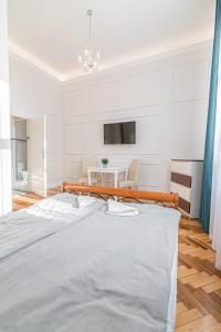 biała sypialnia z łóżkiem i stołem w obiekcie ROYAL Apartments w Krakowie
