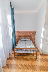 łóżko w pokoju z ceglaną ścianą w obiekcie ROYAL Apartments w Krakowie