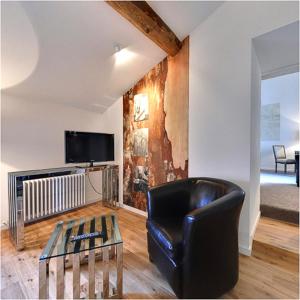 a living room with a leather chair and a table at Le Talluy in Taluyers