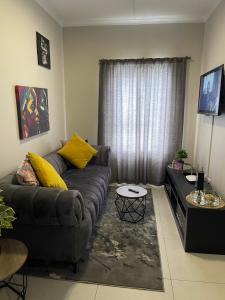 a living room with a couch and a table at Lovely Cozy Apartment in Midrand