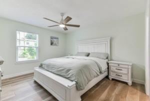 a white bedroom with a bed and a ceiling fan at Bella's Beach House 2811 Avenue O 1/2 in Galveston