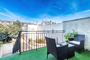 a balcony with two chairs and a table at Appart'Hotel NuiteeJour Versailles Saint Cyr l'Ecole in Saint-Cyr-lʼÉcole