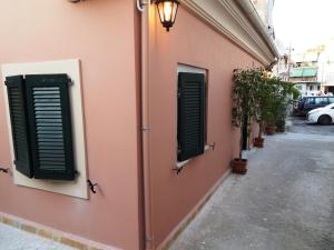 un edificio con dos puertas verdes a un lado. en Sole Apartments - near Corfu Port en Ágios Rókkos