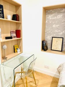 une table en verre et une chaise dans une pièce dans l'établissement Les Suites du Bernascon - Appartement 4 étoiles, à Aix-les-Bains